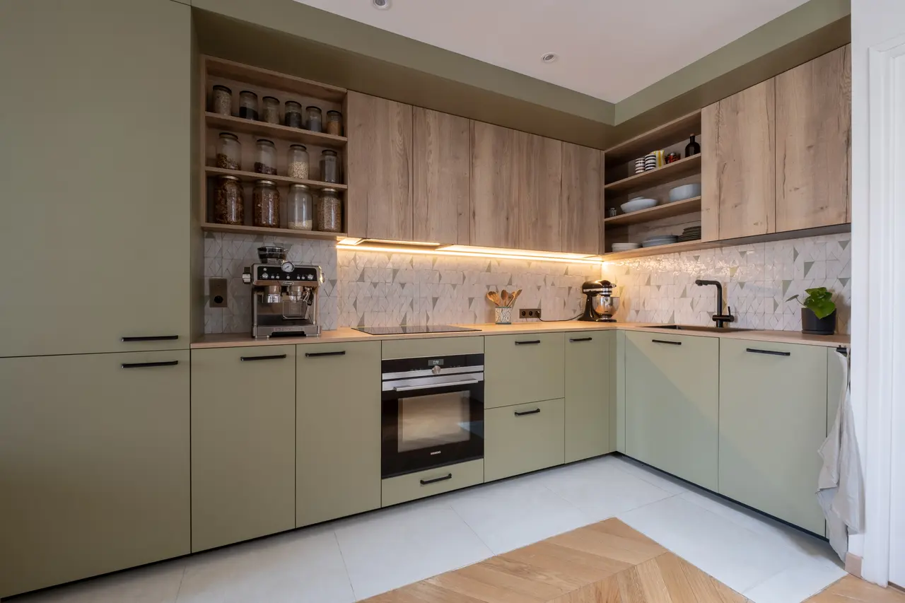 La cuisine éclairée sous les meubles hauts.