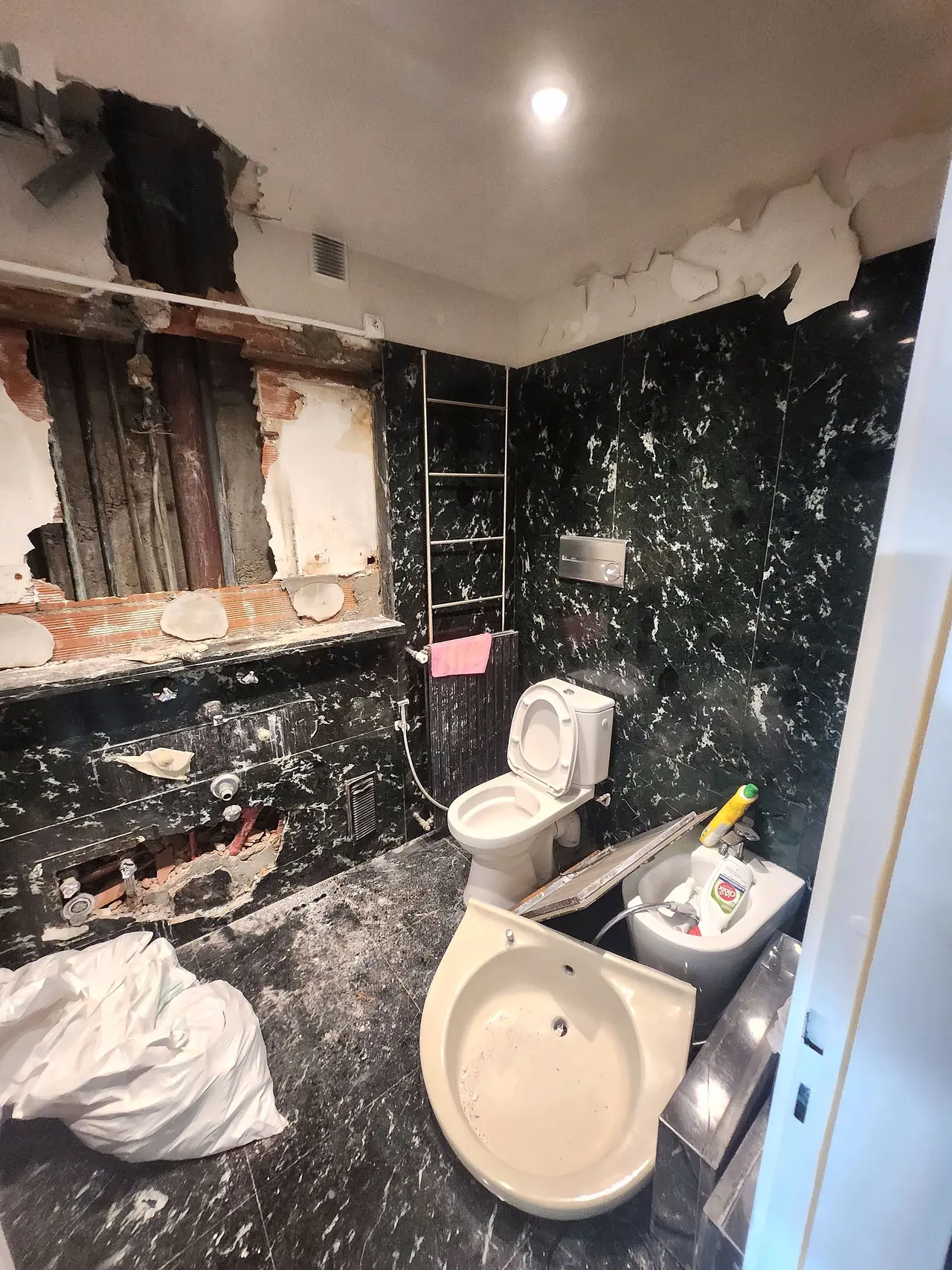 La salle de bains d'origine en marbre noir, au premier jour de la dépose.
