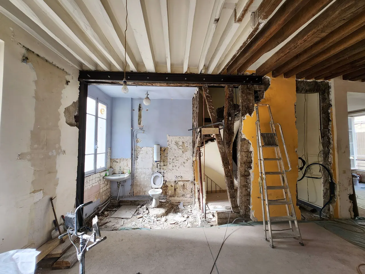 Un portique acier encadre une ouverture dans un mur porteur.