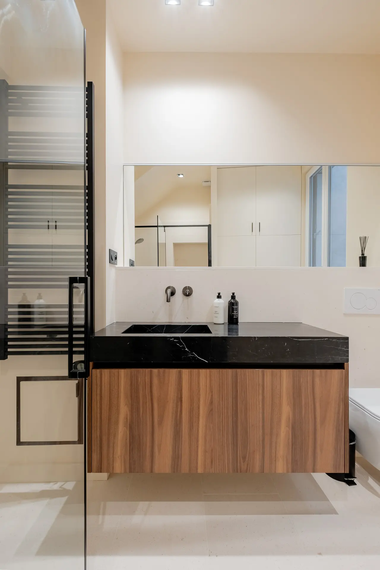 Meuble vasque en noyer et plan en pierre noire.